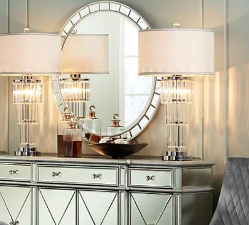 Mirror over a console with table lamps in an entryway